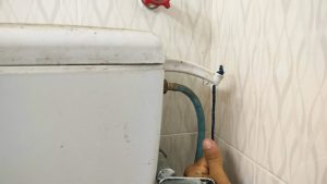 Chauffe-eau en cours de vidange avec un tuyau raccordé à la vanne de purge.